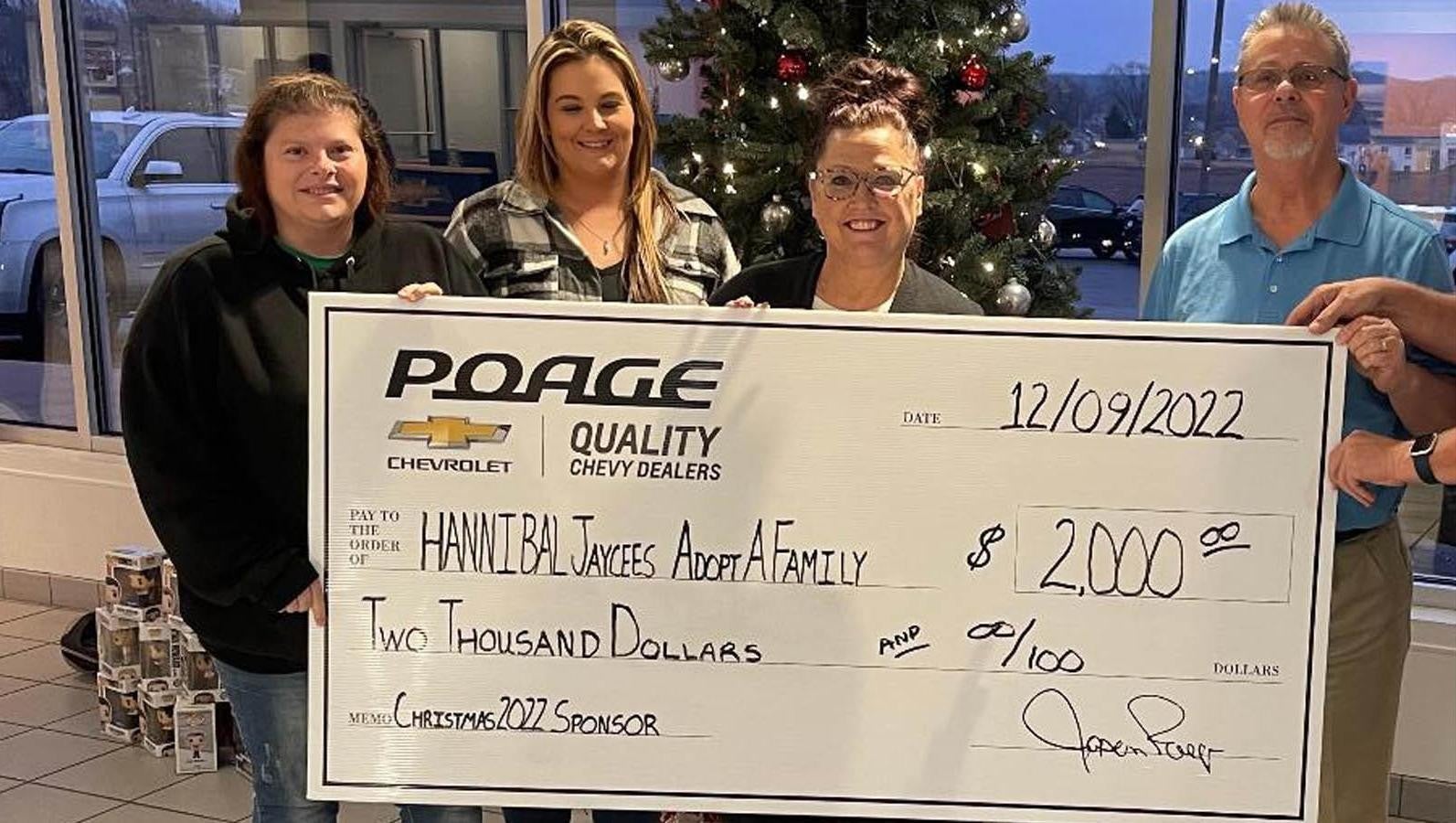 Poage Chevrolet Buick members holding giant check with community members