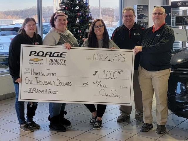 Poage Chevrolet Buick members holding giant check with community members
