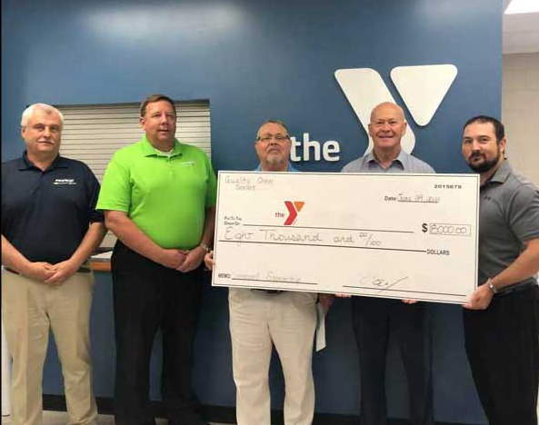 Poage Chevrolet Buick members holding giant check with community members