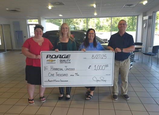 Poage Chevrolet Buick members holding giant check with community members