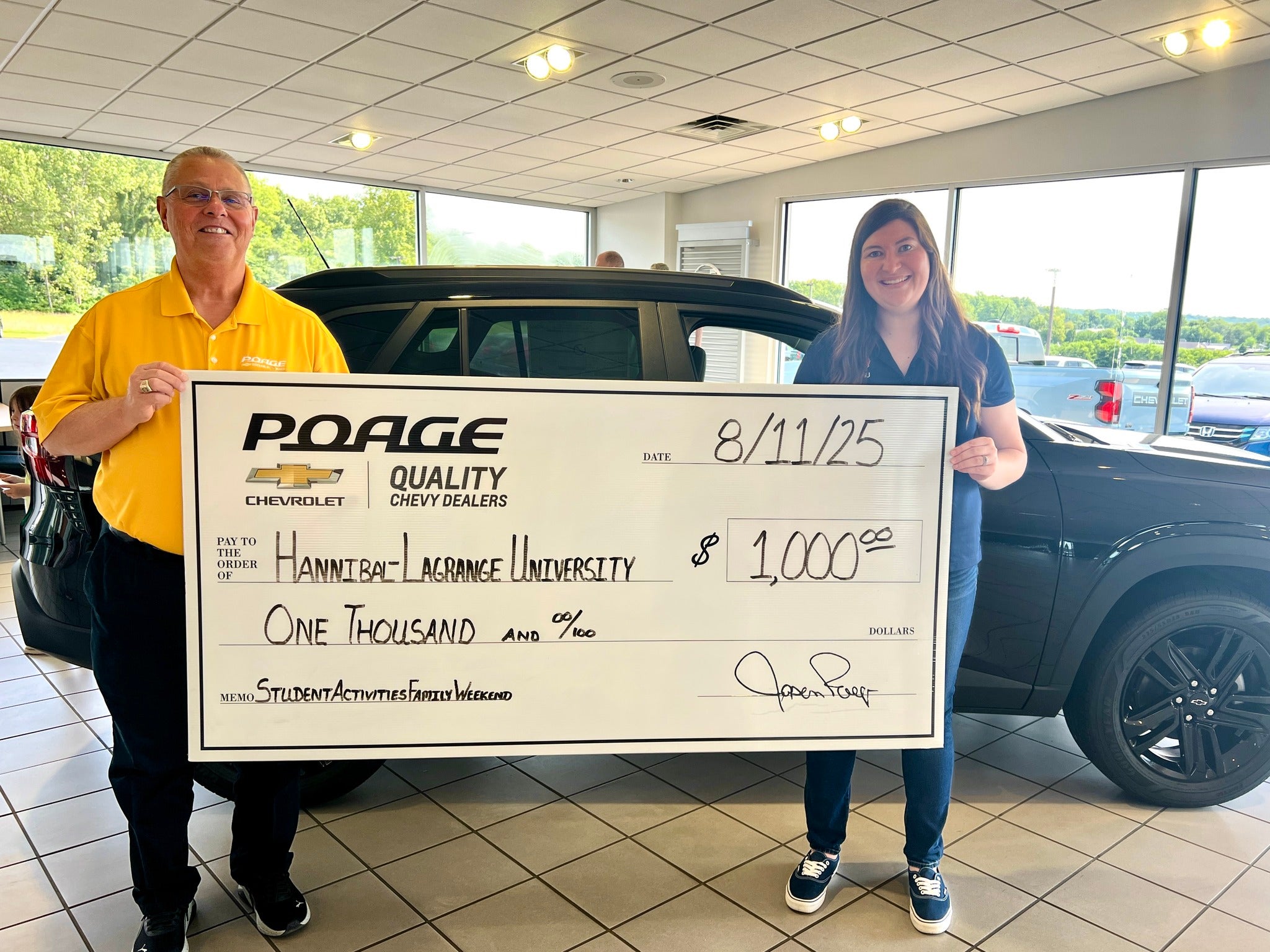 Poage Chevrolet Buick members holding giant check with community members