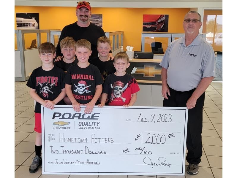 Poage Chevrolet Buick members holding giant check with community members