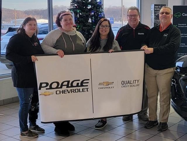 Poage Chevrolet Buick members holding giant check with community members