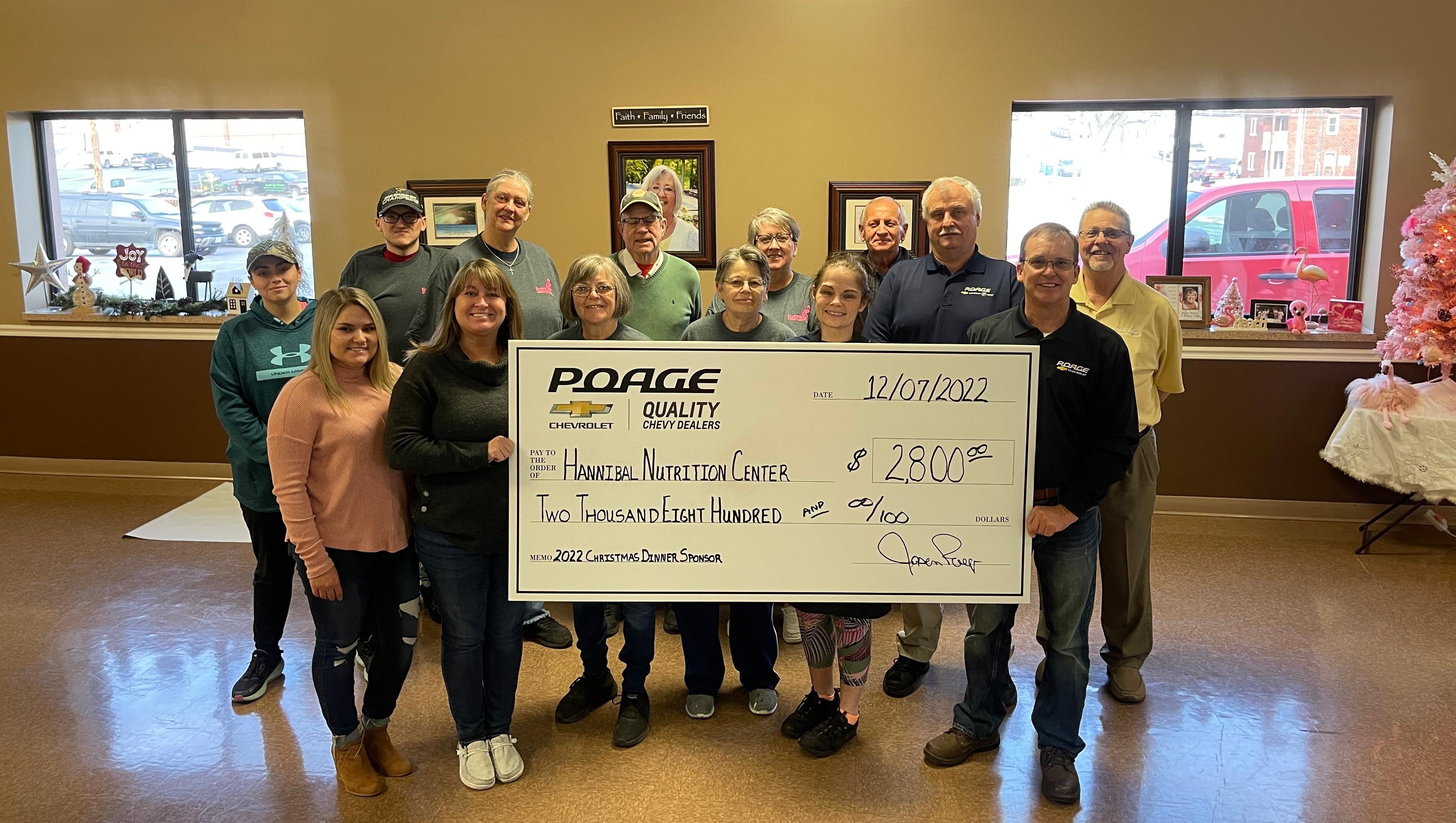 Poage Chevrolet Buick members holding giant check with community members
